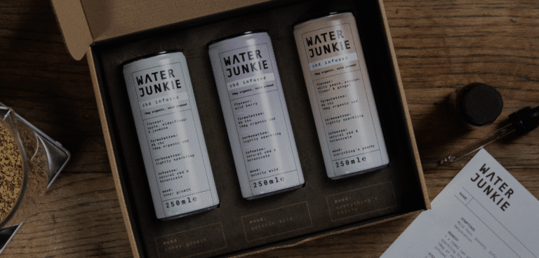 Water Junkie taster pack box open on a wooden surface revealing all three flavours