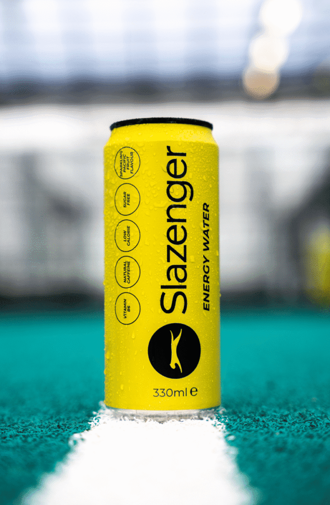 A singular can of Slazenger Energy Water facing the camera whilst on a Padel Court